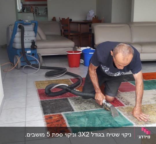 אדם מנקה שטיח עם מכונת ניקוי מקצועית